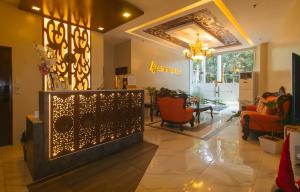 a lobby with a waiting area with chairs and a mirror at Algers Suites Bayan-Bayanan Marikina City in Manila