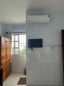 a bathroom with a shower and a white wall at Minh Duc Guesthouse in Phan Thiet