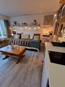 a living room with a bed and a coffee table at Studio rénové avec terrasse, parking , proche pistes,Villard de Lans in Villard-de-Lans