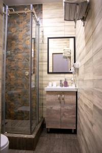 a bathroom with a shower and a sink and a mirror at Tengri Hotel in Aktau