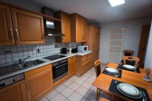 a kitchen with wooden cabinets and a wooden table with a table sidx sidx at Ferienwohnung Haus Mäsch in Wellen