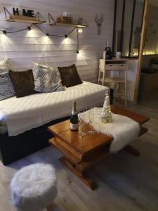 a bedroom with a bed and a table with wine glasses at Studio rénové avec terrasse, parking , proche pistes,Villard de Lans in Villard-de-Lans