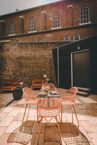 a patio with a table and chairs and a building at Hotel Centraal Baarlo in Baarlo