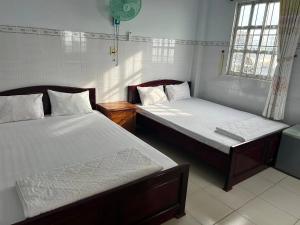 a bedroom with two beds and a window at Minh Duc Guesthouse in Phan Thiet