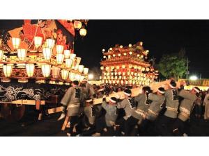 a group of men in uniform walking in front of a building at Comfort stay Miyabi in Chichibu