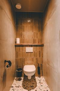 a bathroom with a toilet on a tiled floor at Hotel Centraal Baarlo in Baarlo