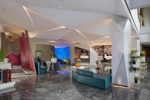 a lobby with couches and tables in a building at Mercure Tai'an Centre in Tai'an