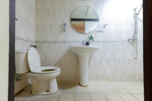 a bathroom with a toilet and a sink and a mirror at RedDoorz Plus near Simpang Tiga Tritayasa Cilegon in Cilegon +22 photos
