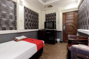 a hotel room with a bed and a television at RedDoorz Plus near Simpang Tiga Tritayasa Cilegon in Cilegon