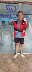 a man standing in front of a glass window at Sheetal Dormitory in Mumbai