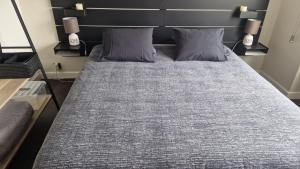 a bed with two pillows on it in a room at Cocoon in East-Brussels in Wezembeek-Oppem