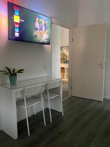 a living room with a table and a tv on the wall at De Keizersmantel in Son