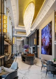 a lobby with chairs and a large painting on the wall at Pullman Beijing South - Newly Renovated in Beijing