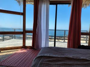 a bedroom with a bed and a view of the beach at Casa La Virgen in Burro Muerto