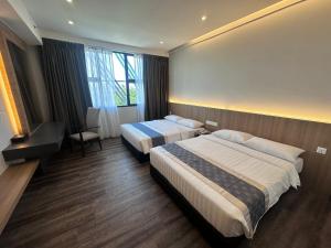 a hotel room with two beds and a window at 56 Hotel Block B in Kuching +13 photos