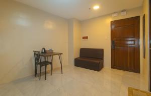 a room with a table and a chair and a door at Algers Suites Bayan-Bayanan Marikina City in Manila