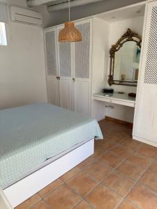 a bedroom with a bed and a mirror at Casa Brisa do Mar in Comporta