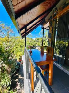 a wooden table on the balcony of a house at Dhanudi Homestay in Ella