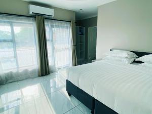 a bedroom with a large bed and a large window at Samanyanga Resort in Kariba
