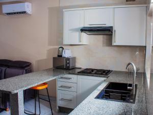 a kitchen with white cabinets and a counter top at Samanyanga Resort in Kariba
