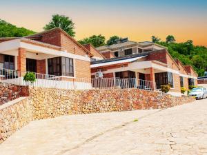 a brick house with a stone wall and a building at Samanyanga Resort in Kariba