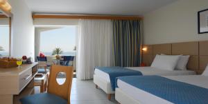 a hotel room with two beds and a view of the ocean at Comer Kinetta Beach in Kineta +31 photos