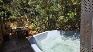 a bath tub sitting on a deck next to a bench at Noordhoek Beach Cabin in Noordhoek