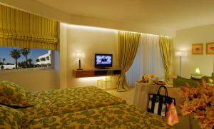 a hotel room with a bed and a television at Comer Kinetta Beach in Kineta