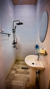 a bathroom with a sink and a mirror and a shower at Kigombe River Motel- musanze in Ruhengeri +33 photos