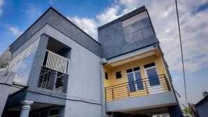 a white and yellow house with a sky at Kigombe River Motel- musanze in Ruhengeri