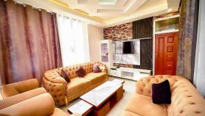 a living room with a couch and a television at Kigombe River Motel- musanze in Ruhengeri