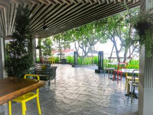 a patio with tables and chairs and trees at Metro Pratunam Boutique Hotel in Pratunam