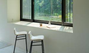 two stools at a counter in a room with windows at Welcome Sunny House in Hongcheon