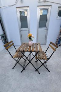 a wooden table with two chairs and a vase with flowers at Limassol center Soul in Limassol
