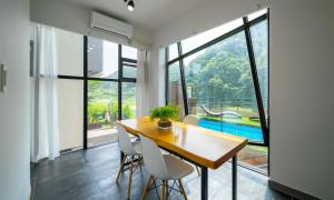 a dining room with a wooden table and white chairs at Welcome Sunny House in Hongcheon
