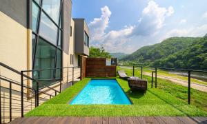 a swimming pool on the side of a house at Welcome Sunny House in Hongcheon