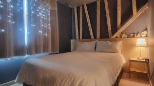 a bedroom with a white bed and a window at Jeju Dalbit Pension in Jeju