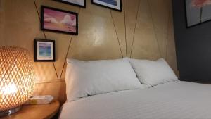 a bedroom with a bed and a lamp and pictures on the wall at Jeju Dalbit Pension in Jeju