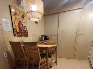 a dining room with a wooden table and chairs at Jeju Dalbit Pension in Jeju