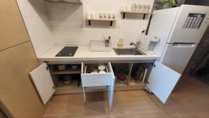 a small kitchen with a sink and a refrigerator at Jeju Dalbit Pension in Jeju +6 photos
