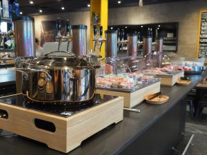 a kitchen with a pot on a counter with food at Hôtel Des Arts in Neuchâtel