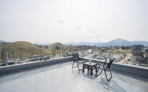 a balcony with two chairs and a table on a building at Gyeongju Wangrim 1984 in Gyeongju