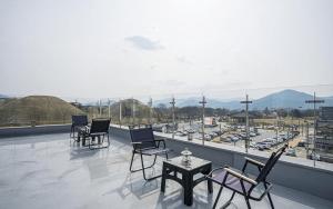 a balcony with chairs and a table and a view of cars at Gyeongju Wangrim 1984 in Gyeongju
