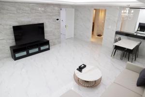 a living room with a couch and a tv and a table at W Residence Hotel Centum City in Busan