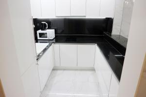 a kitchen with white cabinets and black counter tops at W Residence Hotel Centum City in Busan