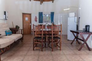 a kitchen with a table and chairs and a refrigerator at Awelani Eco Tourism Lodge in Masisi