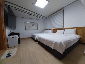 a bedroom with a large bed and a television at Jeonju Dalbitsori Pension in Jeonju +29 photos