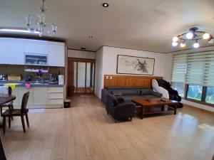 a living room with a couch and a table at Jeonju Dalbitsori Pension in Jeonju