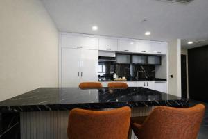 a kitchen with white cabinets and a black counter top at Hilloria Residence Hotel in Serdivan