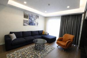 a living room with a blue couch and a chair at Hilloria Residence Hotel in Serdivan
